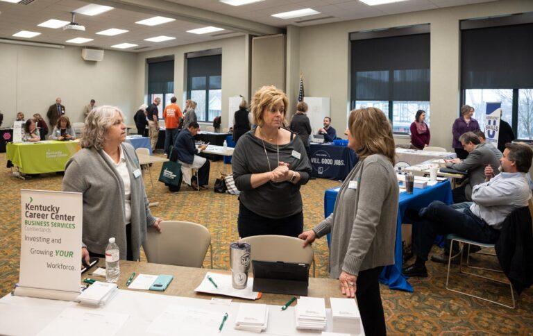 people in a room with various table with employers
